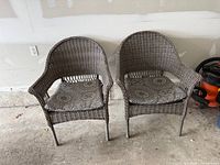 Front view of both matching wicker patio chairs with cushions