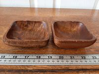 Two square wooden bowls beside ruler showing width