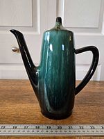 Full side view showing glaze, spout, handle, and scale