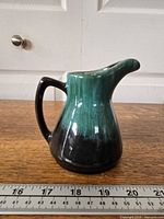 Profile view of jug beside ruler showing height about 4.5 in