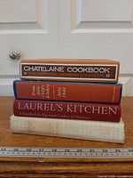 Stacked view showing four cookbook spines with ruler for scale