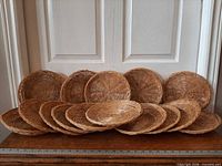 Front view of all 15 woven chargers lined up against door