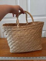 Front view of woven basket tote showing overall shape and handles