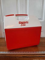 Front and top view showing Igloo Playmate Elite branding, red body, white lid, carry handle
