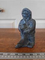Front view of soapstone Inuit figurine with ruler for scale