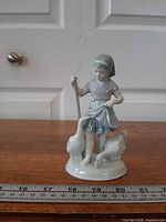 Full front view of porcelain figurine with ruler for scale