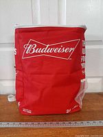 Front view of red Budweiser cooler backpack with ruler for scale