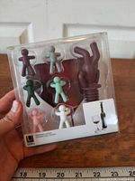 Front view of sealed Umbra Drinking Buddy wine bottle stopper and glass charms package