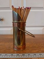 Matchstick holder front view showing copper bands, striker slot, handle and matches