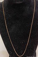 Full length view of gold chain on display bust