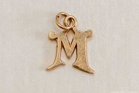 Front view of gold M pendant with jump ring