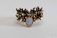 Front view showing pear opal, small round opal, brutalist gold surround