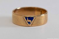 Front view of gold band with blue enamel emblem
