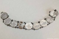 Full view of bracelet showing eight coins linked in a curve