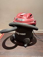 Front view of Shop-Vac showing hose, body, casters