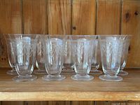 group of nine etched crystal goblets on shelf
