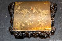 Closed compact showing etched brass lid and carved dark border