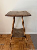 Full view of bamboo side table showing top, legs and lower shelf