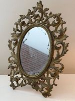 Full view of oval brass mirror on stand