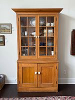 Front view of entire cabinet showing glass doors and solid lower doors