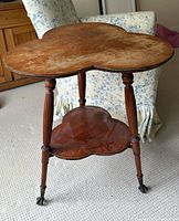 Full view showing clover top, lower shelf, three legs with glass ball feet