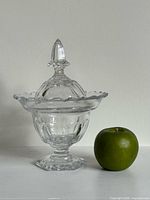 Full view of candy dish beside apple for scale