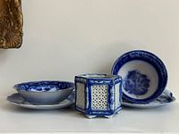 Group shot of flow blue dishes: two plates, two bowls, hexagonal container