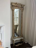 Full view of mirror with console and detached cornice at base