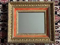 Front view of rectangular gilt wood mirror with orange velvet liner