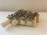 Perspective view of chime lying flat showing four resonator tubes and steel tone bars