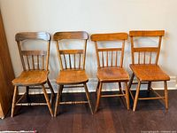Full view of all four wooden chairs aligned side by side