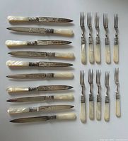 Full set of 11 knives and 9 forks laid out