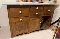 Front view showing drawers, doors, missing right door, metal top