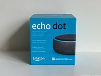 Front of sealed blue retail box showing Echo Dot image and branding