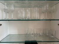 Cabinet view showing stemmed wine glasses and highball glasses on upper shelf