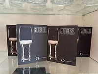 Four retail boxes of Riedel The O Champagne Tumbler glasses on shelf