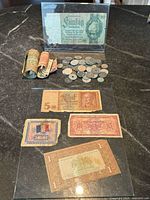 Overall lot showing coins, rolled notes and two note holders