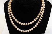 Full view of doubled faux pearl necklace displayed on bust