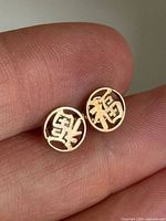 Close-up of both earrings showing Chinese characters and gold tone
