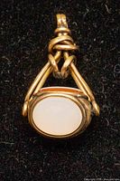 Front of pendant showing white agate face within gold-filled frame