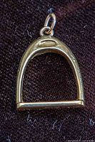 Front view of gold stirrup charm with jump ring