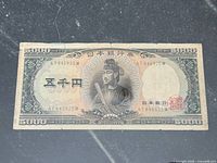 Obverse of 5000 yen note showing portrait, serial number and folds