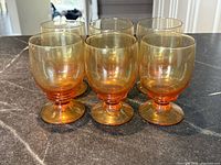 Six amber footed glasses grouped to show set