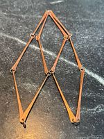 Full view of copper necklace laid flat showing overall design