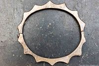 Front view of oval sterling bracelet showing scalloped edge and hinge