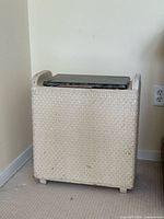 Front view of painted wicker laundry hamper with faux marble lid
