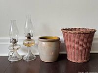 Group shot showing both oil lamps, crock and wicker basket