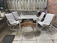 Full view of outdoor table with four swivel chairs