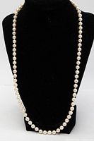 Full view of pearl necklace displayed on black bust