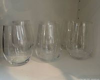 Six clear stemless Riedel tumblers on shelf